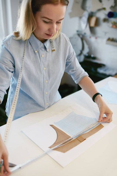 Female Tailor Measuring Sewing Pattern On Table - Fotografie, Obrázek