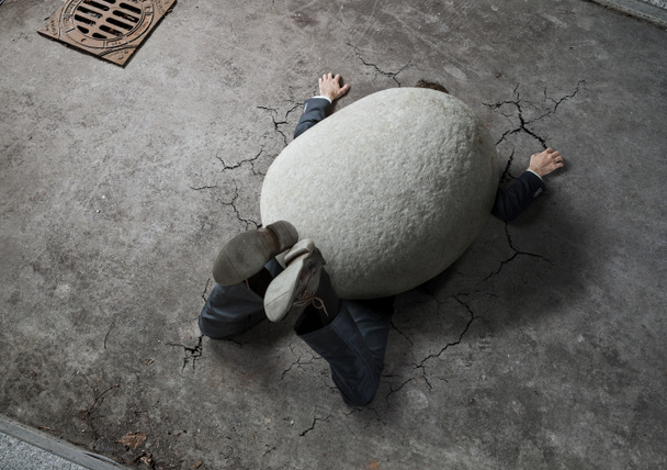 High angle view of businessman crushed by the huge stone on the street with copy space  - Photo, Image
