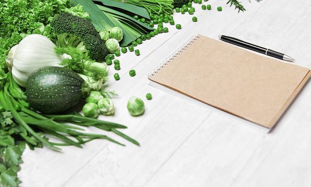 Shopping List. Green Vegetables And Notebook On Table - Foto, Imagem