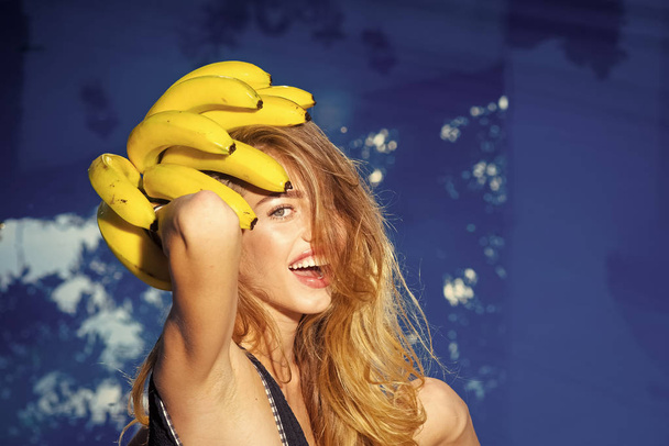Summer vacation and travel to ocean. Vitamin in banana at girl near water. Dieting and healthy organic food, vegetarian. Woman relax in spa luxury swimming pool. Sexy woman with tropical fruit in pool - 写真・画像