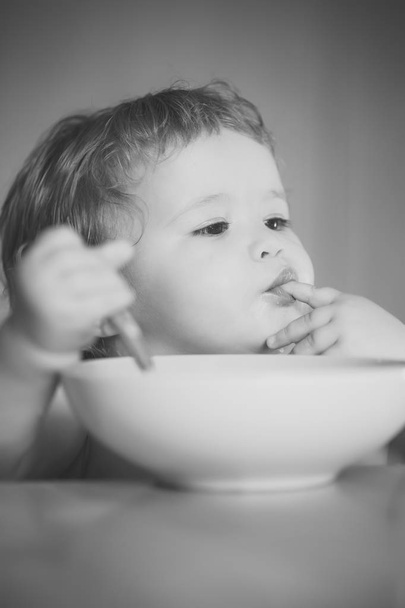 Portrait of serious boy eating - Photo, image
