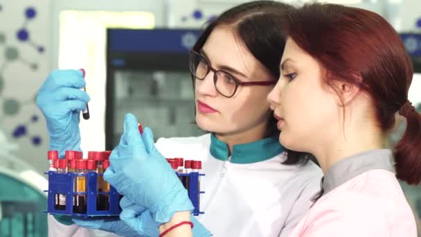 Дві молоді жінки-дослідниці працюють з пробірками крові
 - Кадри, відео