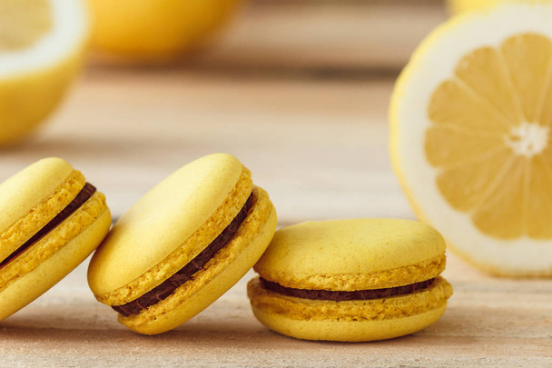 Yellow french macarons with lemons on the wooden boards - Fotó, kép