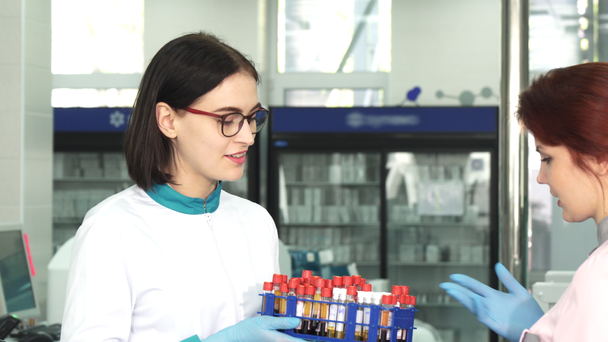 Θηλυκό ερευνητής παραδίδοντας δείγματα αίματος για τον συνάδελφό της - Πλάνα, βίντεο