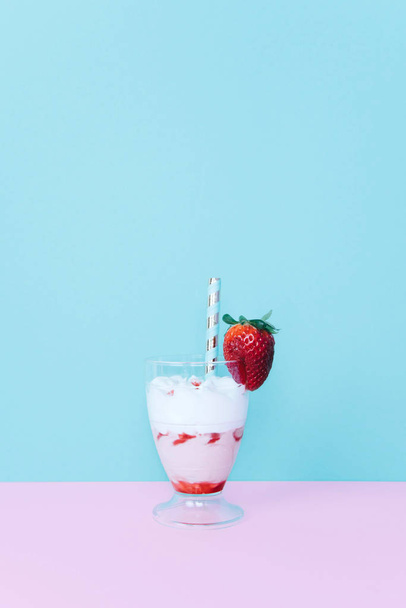 Milkshake with straw and strawberry. - Фото, зображення