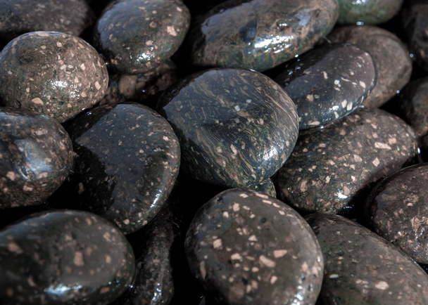 Superficie húmeda de piedra negra del río en el suelo junto a la cascada
 - Foto, Imagen