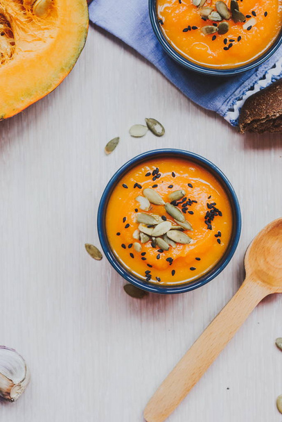 Roasted pumpkin soup with pumpkin seeds on wooden background. - Photo, Image