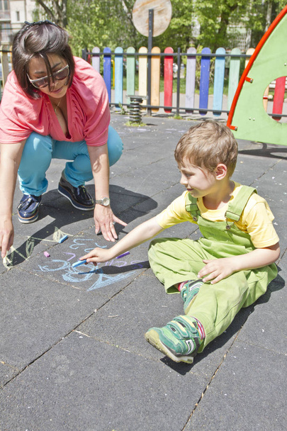 Mama i chłopiec cute narysować alfabet z Kolorowe kredki na asfalcie. Letnich aktywności i kreatywne gry dla małych dzieci. Czasu z rodziną. Szczęśliwy dzień matki. Matka i dziecko razem, zabawy.  - Zdjęcie, obraz