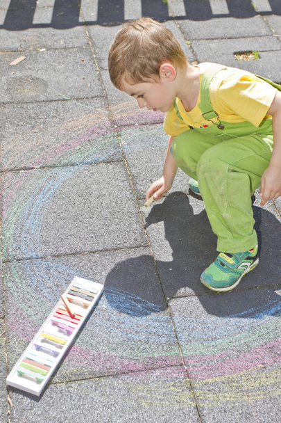 Sevimli çocuk ile renkli tebeşirler asfaltta çizer. Yaz etkinliği ve yaratıcı oyun küçük çocuklar için. Çocuk eğleniyor birlikte. Okul ve tatil kavramı. Eğitim kavramı.  - Fotoğraf, Görsel