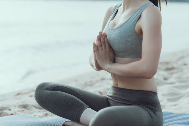 Young woman is engaged in yoga at seaside. - Φωτογραφία, εικόνα