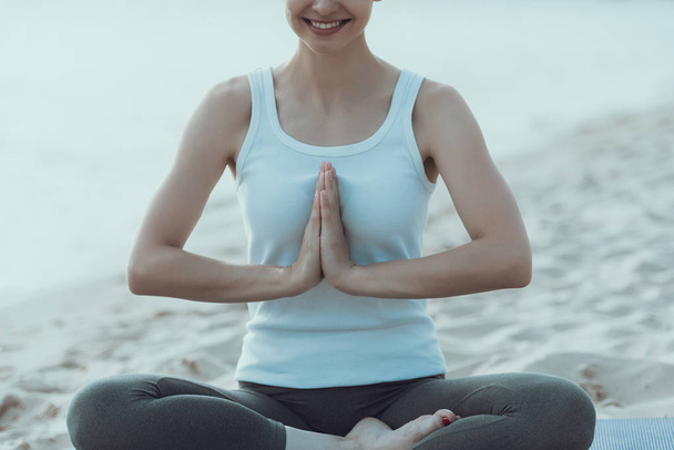 Young woman is practicing yoga at seaside. - Фото, зображення