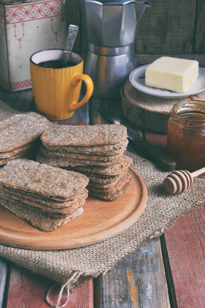 Healthy food concept. Breakfast with crispbreads, butter, jam, coffee. Flatbread crackers with sesame, flax seed, pumpkin and sunflower seeds. Diet crispy cookies. Snack gluten-free. Copy space - Photo, Image