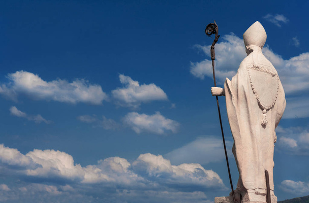 Statua del vescovo con nuvole
 - Foto, immagini