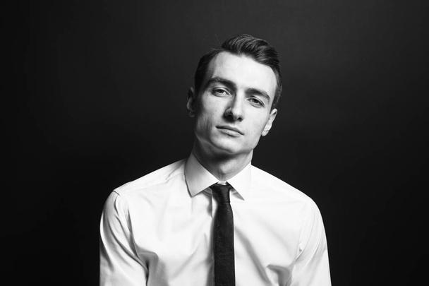 Retrato de un joven con camisa y corbata negra
 - Foto, imagen