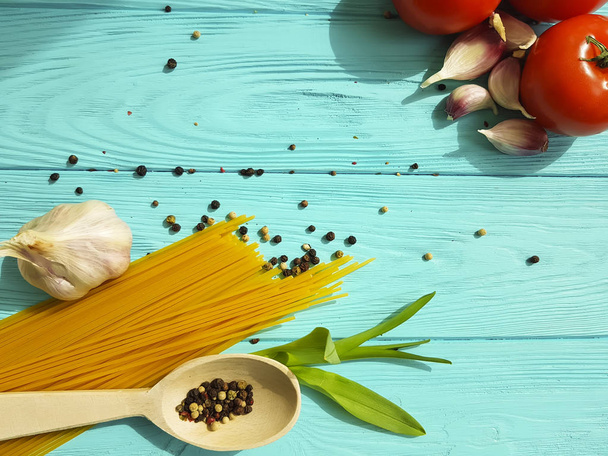 espaguetis, ajo, pimienta sobre un fondo de madera azul
 - Foto, Imagen