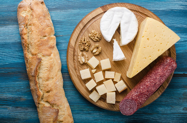 Ассорти сыров на круглой деревянной доске
 - Фото, изображение
