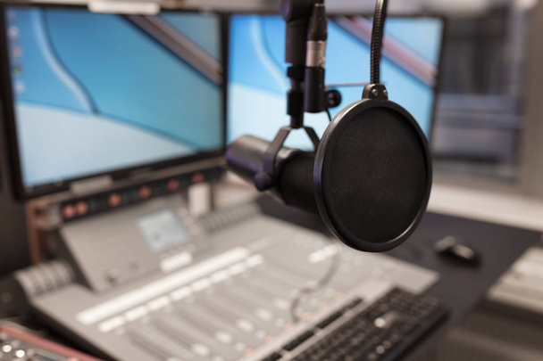 Οθόνες και το μικρόφωνο πάνω από το τραπέζι σε ραδιοφωνικό στούντιο - Φωτογραφία, εικόνα
