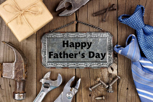 Happy Fathers Day message on metal sign with frame of tools, gifts and ties on a wooden background - Fotoğraf, Görsel