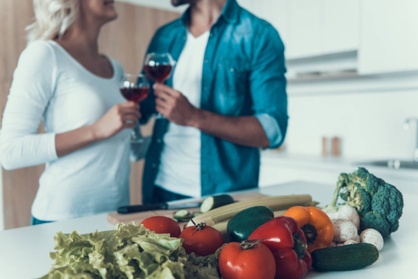 Loving couple with glasses of wine prepare breakfast together. - 写真・画像