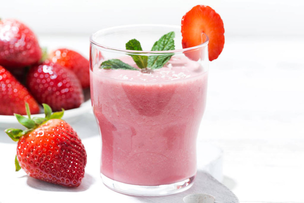 refreshing strawberry milkshake on white table, closeup - Foto, afbeelding