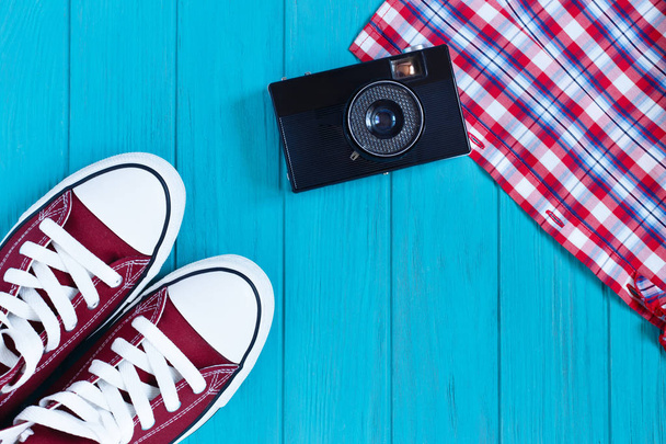 Sneakers, vintage camera, checkered shirt on bright turquoise ba - Foto, Imagem