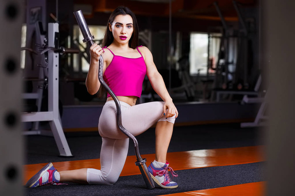 Giovane attraente muscolare sexy fitness donna in posa con bilanciere
 - Foto, immagini
