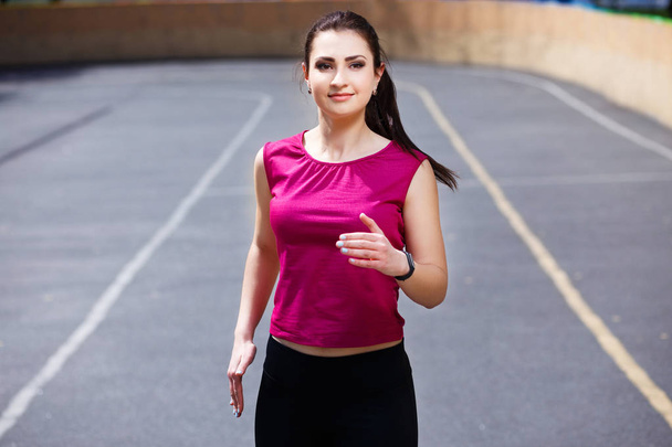 Young pretty fit woman jogging at the athletic field - Fotoğraf, Görsel