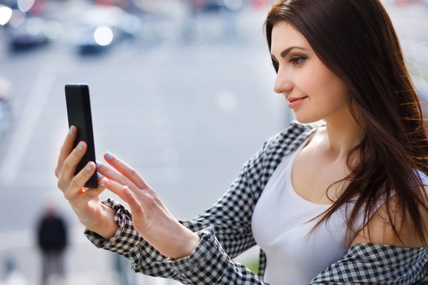 Молода красива стильна жінка бере селфі на смартфон в
 - Фото, зображення