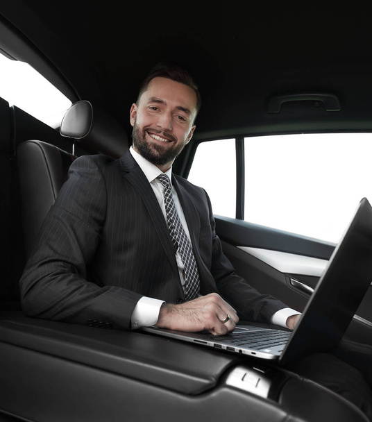 successful man working with laptop sitting in car - Foto, afbeelding
