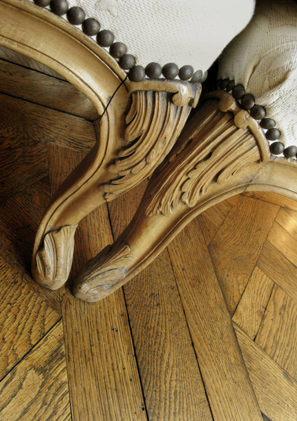 Elegáns fából készült fotel, egy fából készült padló, belsejében egy francia kastély közelről - Fotó, kép