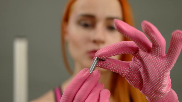 Sexy žena dává podložka šroub v konstrukci rukavice - Záběry, video