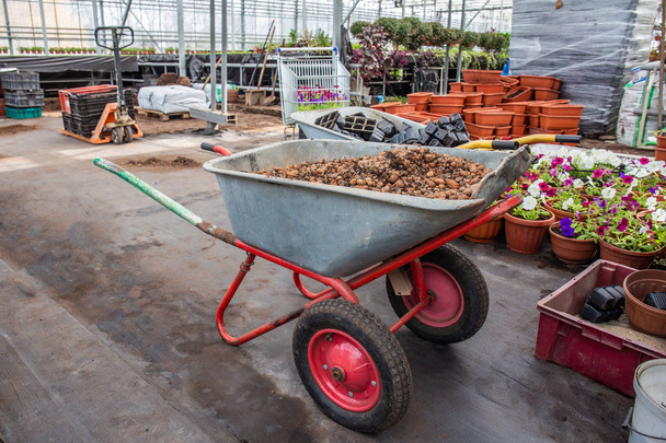 Wheelbarrow soralla sisällä moderni kasvihuone, teollisuuden puutarhanhoito laitteet puutarhanhoito
 - Valokuva, kuva