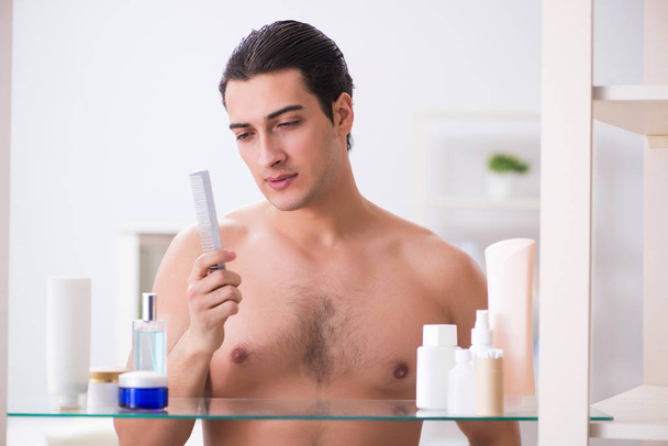 Young man is getting prepared for working day in bathroom - Photo, Image