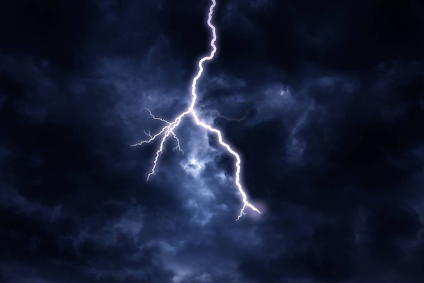 A lightning strike on a cloudy dramatic stormy sky. - Photo, Image
