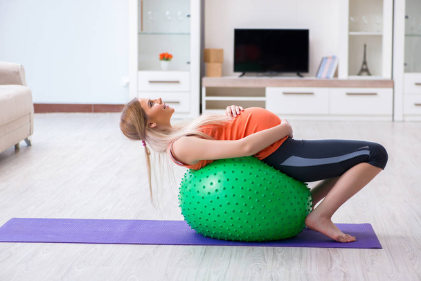 Young woman preparing for birth exercising at home - Photo, Image