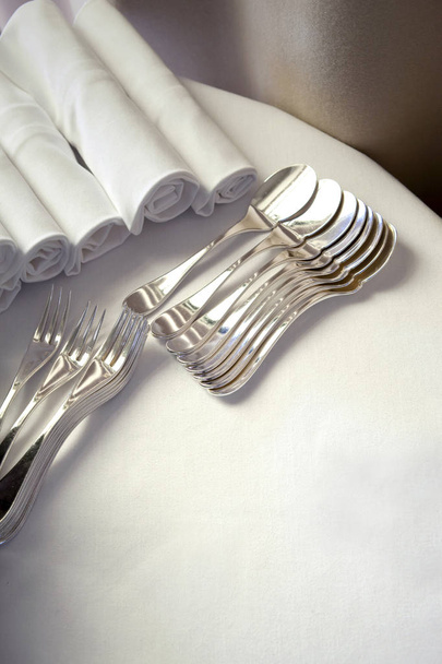 Cucharas tenedores y servilletas en una mesa
 - Foto, imagen