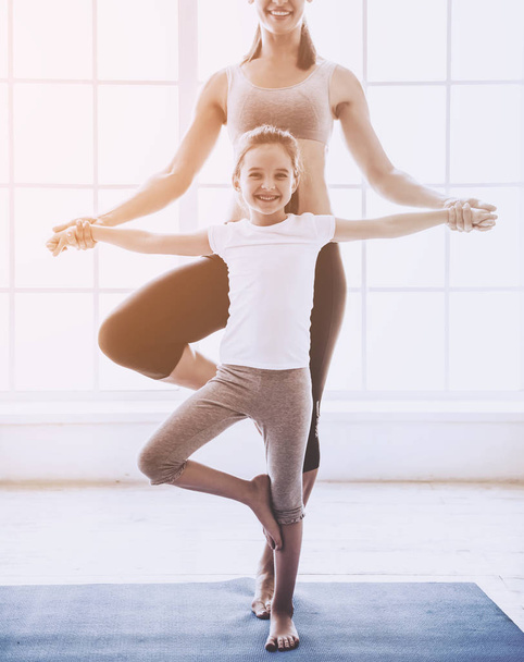 Mother and daughter doing yoga - Foto, afbeelding