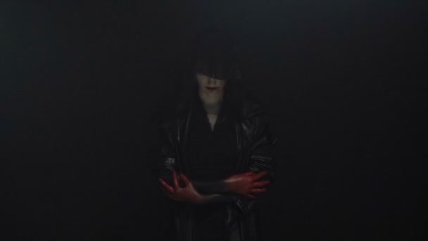 Kobieta w czarny kaptur z rąk krwi - Materiał filmowy, wideo