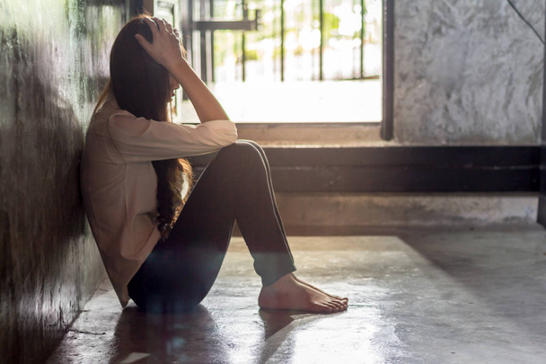 Молодая женщина со стрессом сидит в комнате, грустная депрессия женщина
. - Фото, изображение