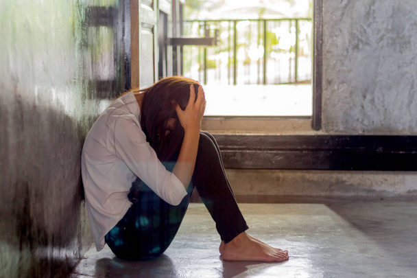 Depressive junge Frau sitzt im leeren Raum, traurige Depression weiblich. - Foto, Bild