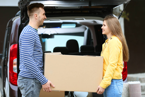 Young couple unloading their car on moving day - Foto, Imagem