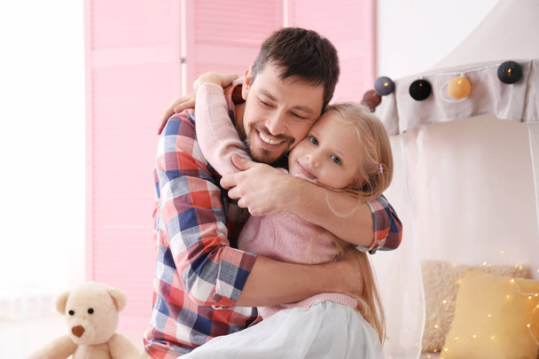 Cute little girl and her father hugging at home - Foto, imagen