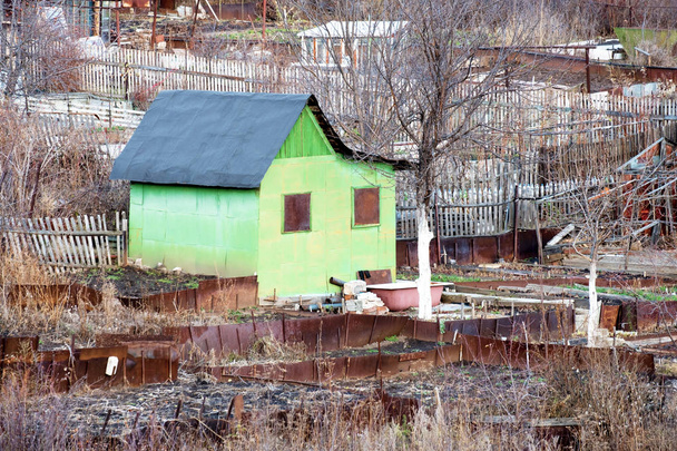 un bâtiment vert pour la vie, une pauvre serre au milieu d'une clôture en fer et des arbres d'automne, la Russie
 - Photo, image