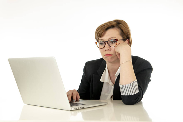 Young beautiful re haired caucasian stressed business woman in glasses working on her laptop looking worried, tired, overwhelmed and unhappy. business, overwork, deadline and technology concept. - Foto, afbeelding