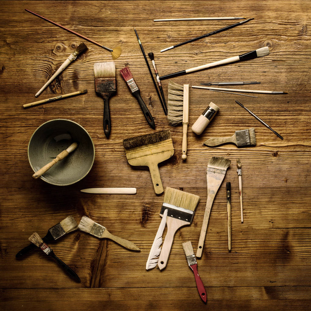 pintura naturaleza muerta con muchos cepillos de tipo y otras herramientas sobre un fondo de madera
 - Foto, imagen