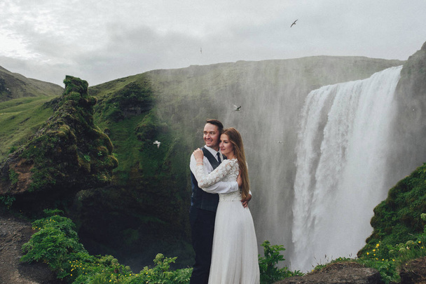 married couple posing outdoor on waterfall background - Fotó, kép