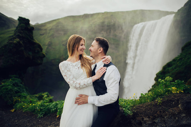 married couple posing outdoor on waterfall background - Φωτογραφία, εικόνα