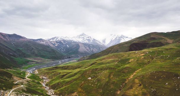 Piękny widok na pokryte śniegiem i roślinnością góry Kaukazu - Zdjęcie, obraz