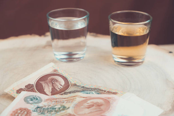 dvě sklenky alkoholem před nimi staré peníze z oběhu SSSR - Fotografie, Obrázek