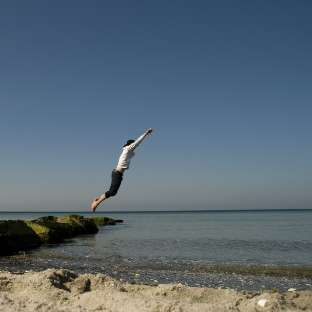 persoon springen op het strand - Foto, afbeelding